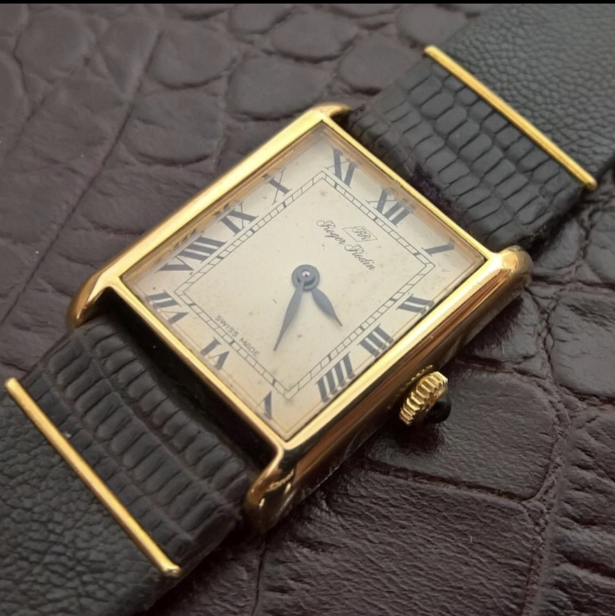 Vintage Roger Rodin tank watch, gold case, cream dial with Roman numerals, Swiss Made, on dark crocodile leather.